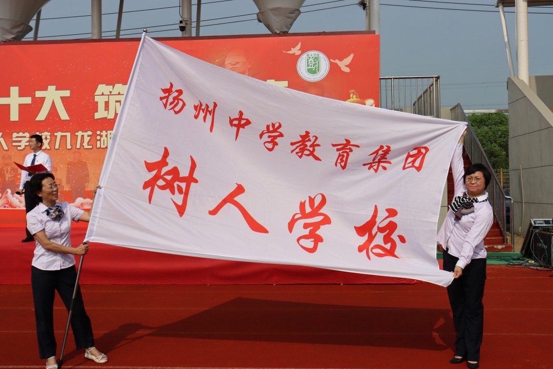4.九龙湖校区校长殷翠云和树人副校长童敏娟展示树人旗.JPG