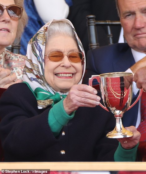 57771159-10812857-Her_Majesty_smiled_broadly_as_the_trophy_was_presented_to_huge_c-a-119_1652444311024.jpg