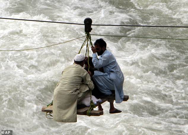 61878699-11161671-People_cross_a_river_on_a_suspended_cradle_in_the_town_of_Bahrai-m-53_1661882821740.jpg